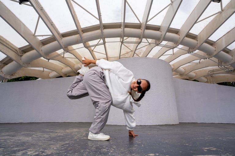 Athletic woman breaking and posing in sportswear under an urban structure